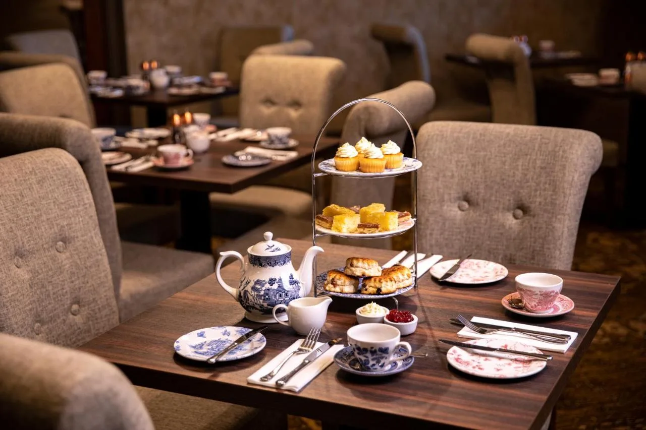 a table with a tray of pastries and cups on it at The Station Hotel in Aberdeen